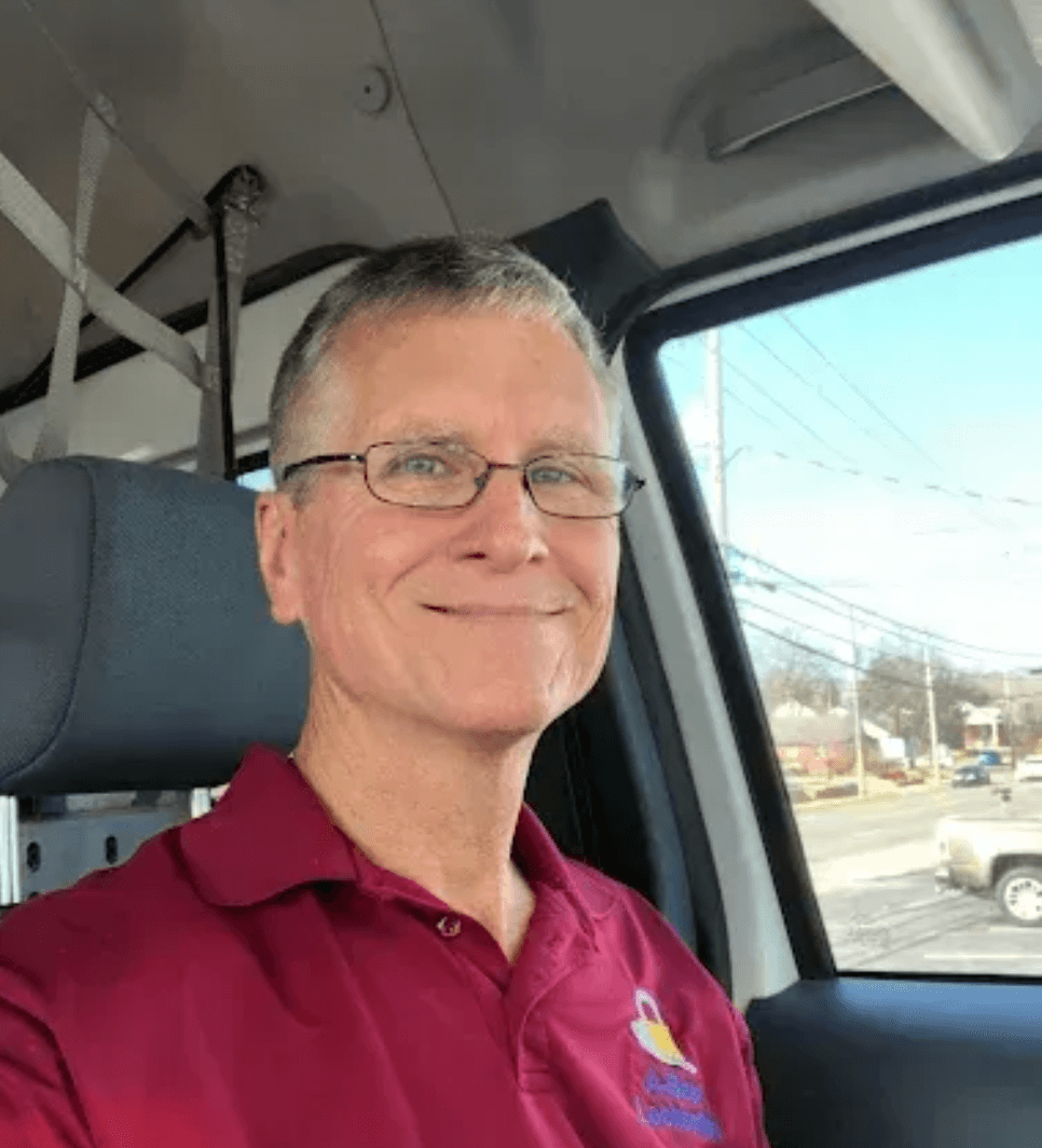 Man wearing burgundy polo shirt with logo in vehicle cab
